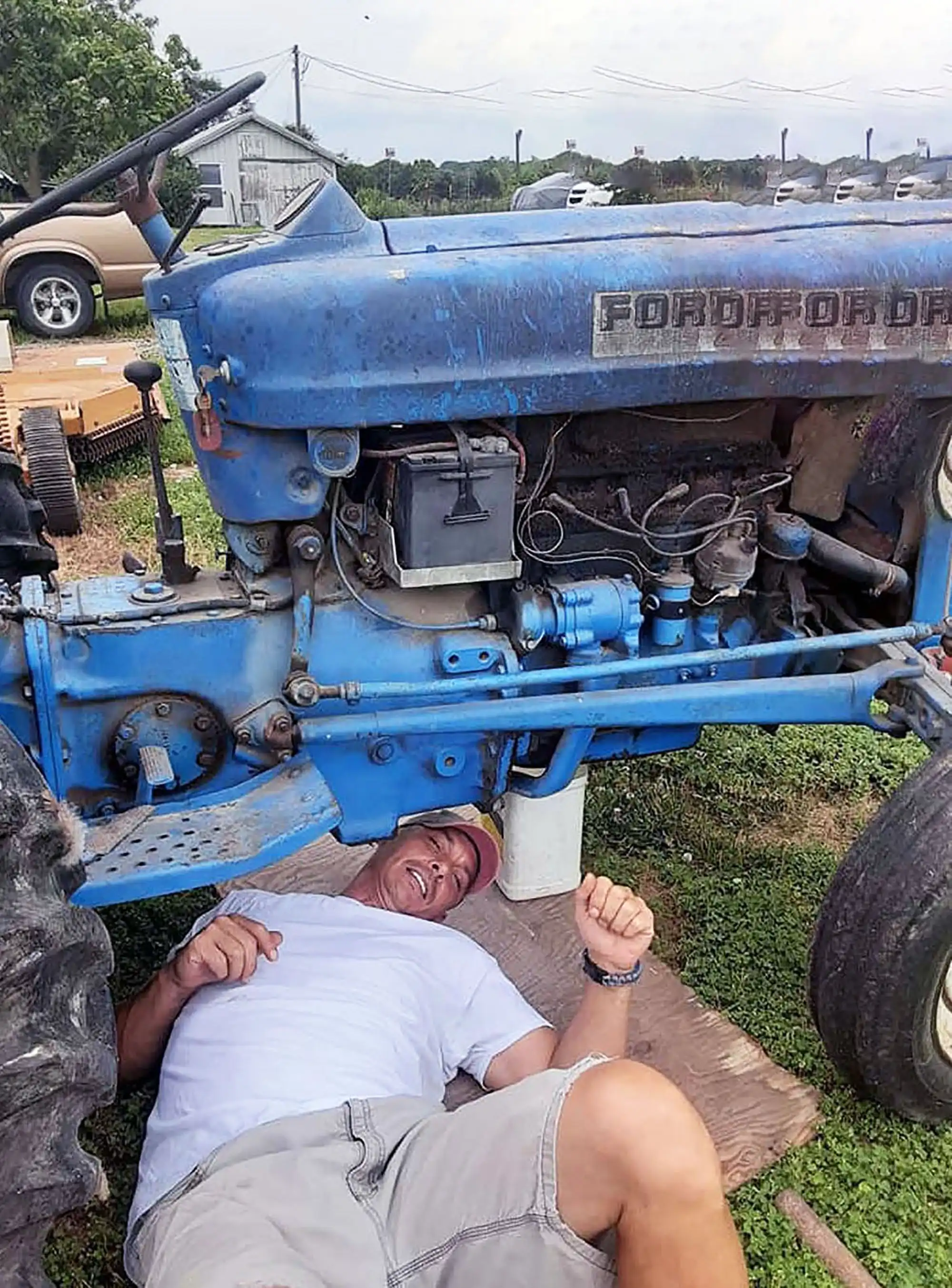 Working on the blue tractor from the book Spring Break to Mars, author David Haave gives it a tune up on the Wassman's farm, Tipton, MO, USA.